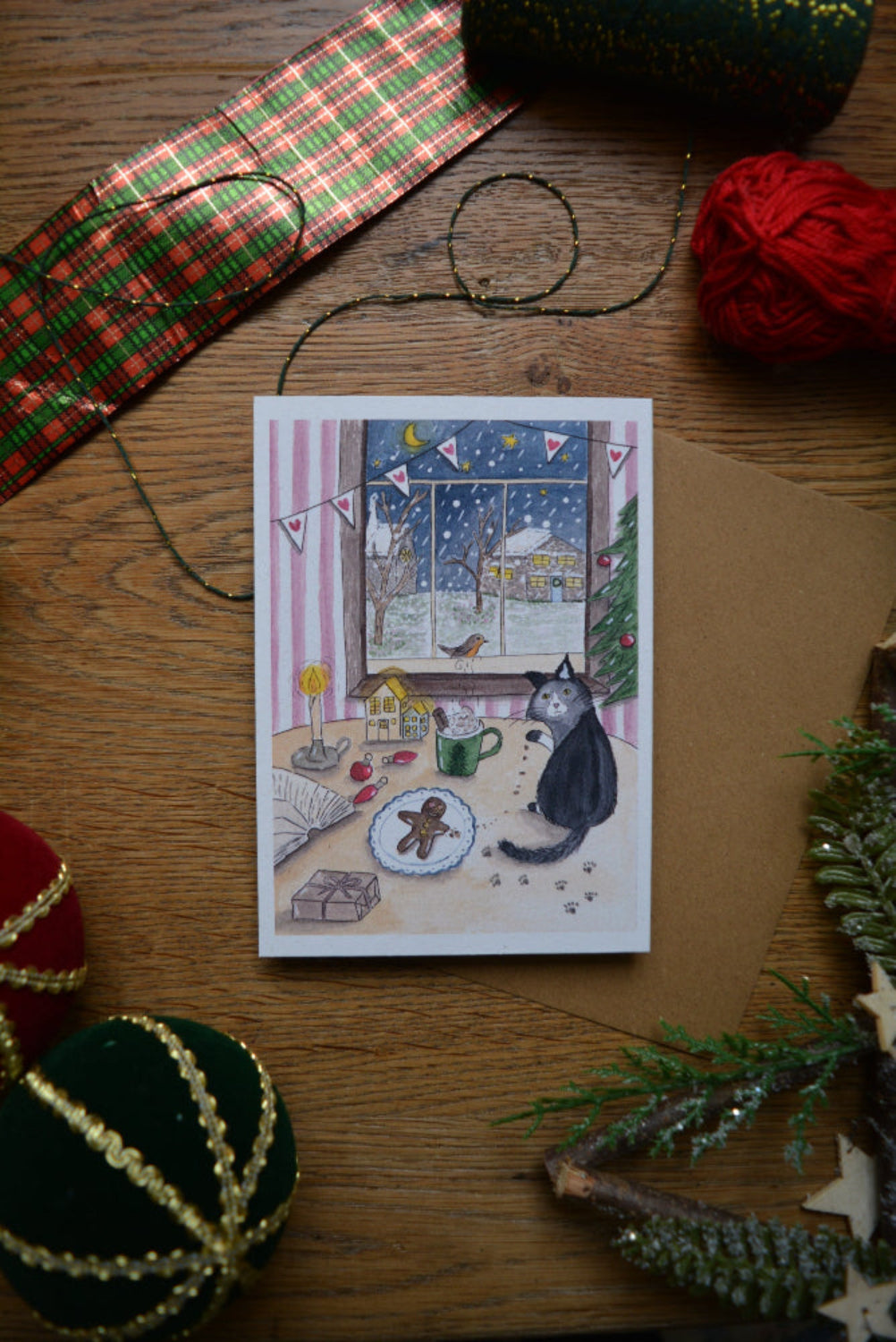 carte postale chat de noël devant une fenêtre