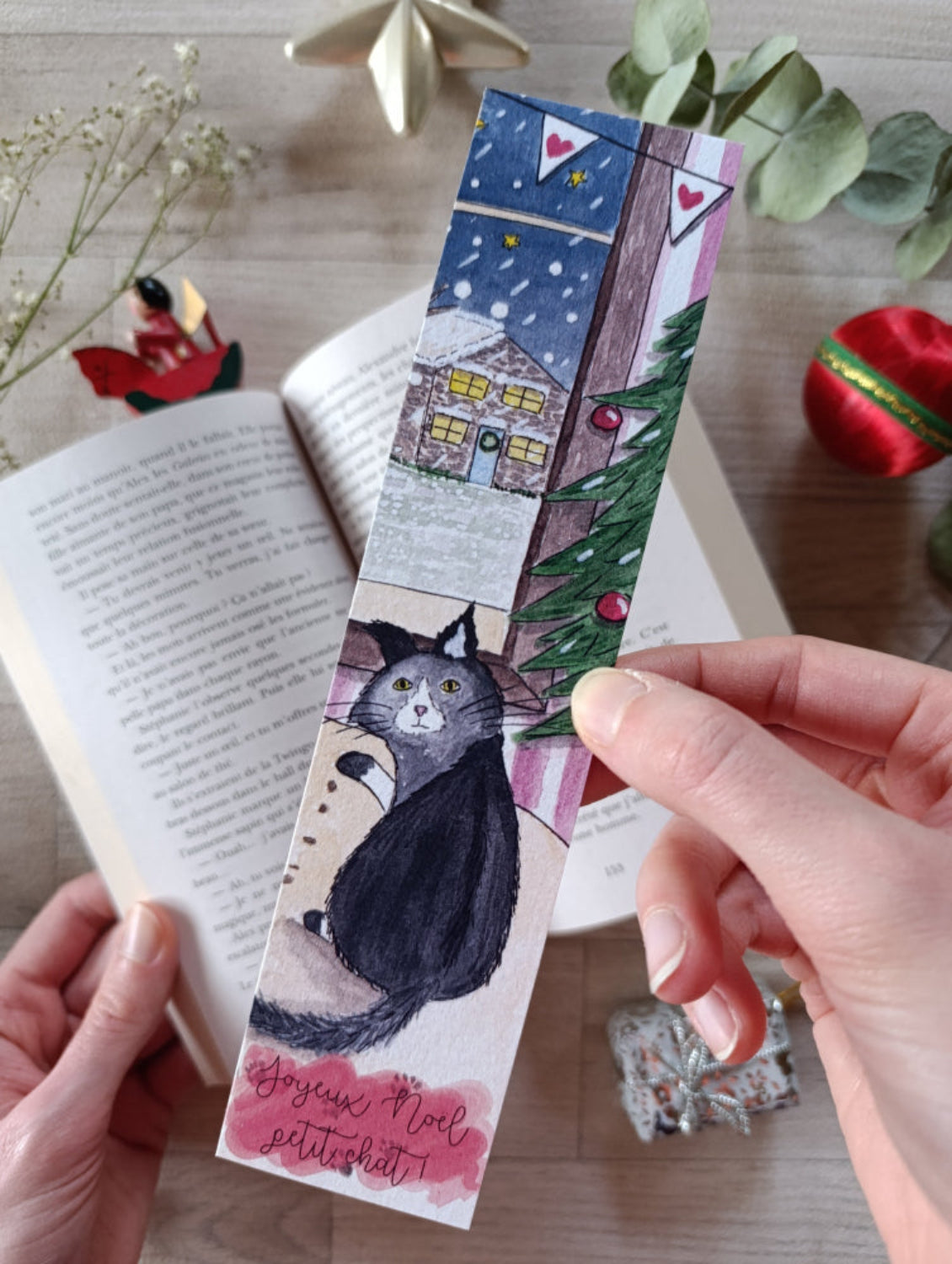 marque page tenu dans ma main sur un livre